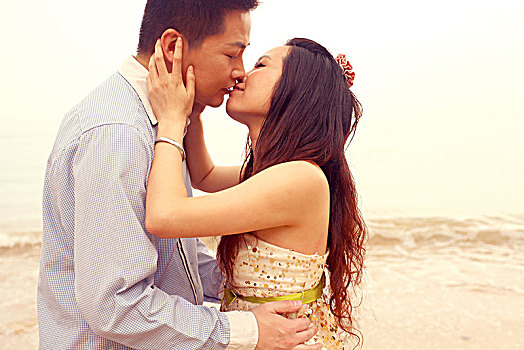 海边浪漫亲吻的亚洲情侣