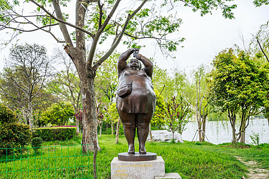 中国江苏省苏州金鸡湖湖畔公园胖女人拍照雕塑
