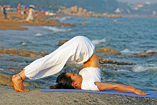 海边练瑜伽的女孩