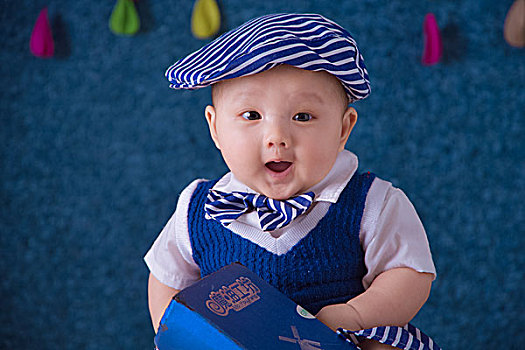 戴帽子的穿蓝色衣服的快乐中国宝宝