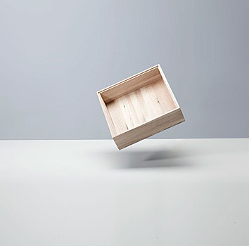 浅色背景前漂浮的木盒