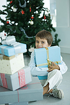 男孩,坐,靠近,一堆,圣诞礼物,拿着,一个,胸部