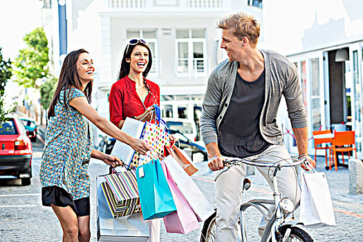 男青年,骑自行车,两个女人,跑,购物袋