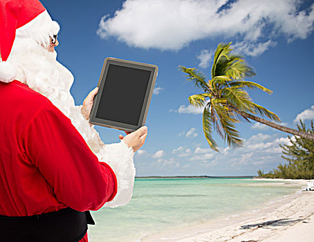 圣诞节,休假,广告,科技,旅行,人,概念,男人,服饰,圣诞老人,平板电脑,电脑,展示,留白,显示屏,上方,热带沙滩,背景