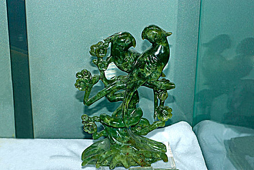 碧玉雕刻成的两只鹦鹉落在枝头上