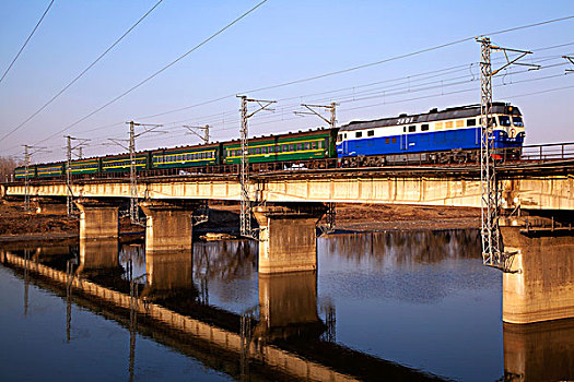 客运火车驶过老旧的铁路桥