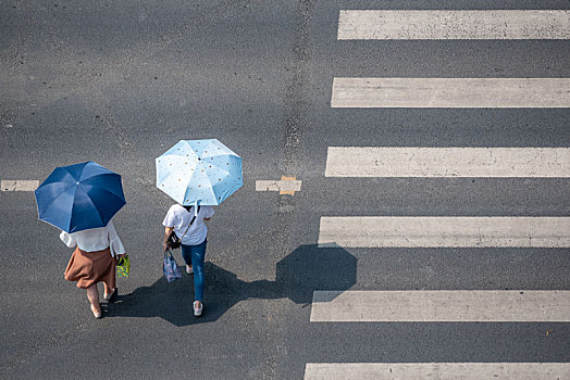 人行道上过路的打伞美女