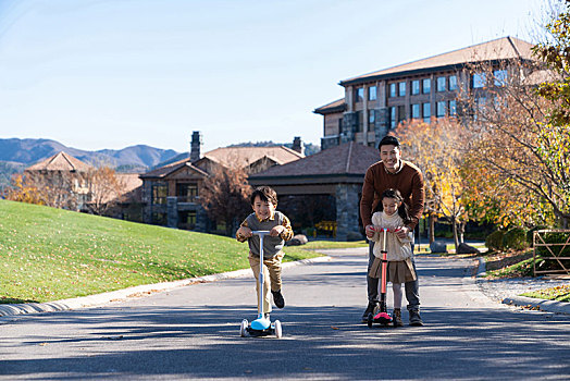 爸爸带着孩子们在玩滑板车