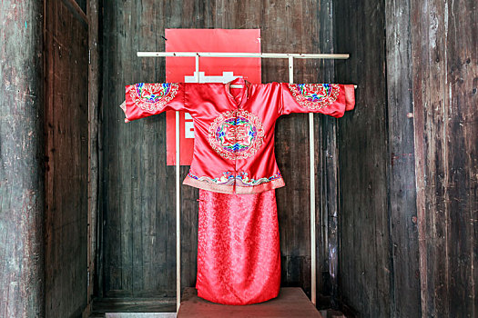 徽式老屋内的红色中式婚礼服