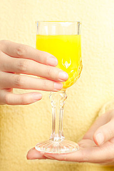 手上端着一杯橙子汁