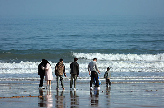 蔚蓝大海让人心旷神怡,游客漫步沙滩放飞心情