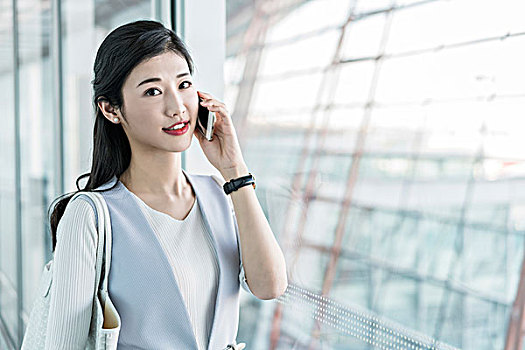 年輕商務女士在機場打電話