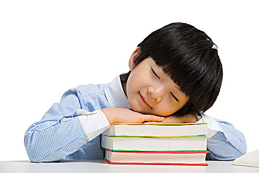 小男孩趴在书本上睡觉