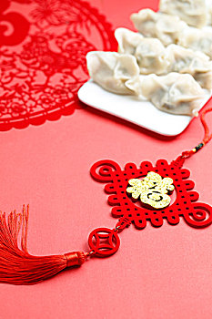 饺子和中国结,鸡年剪纸放在红色背景上