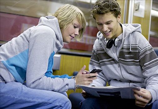 两个,青少年,打手机,报刊,城市,列车,倾斜,风景