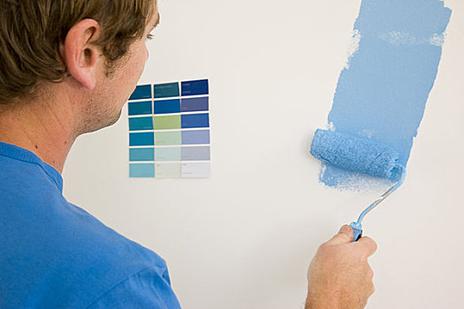 后视图,男人,拿着,油漆滚,上油漆,白墙,蓝色,颜料