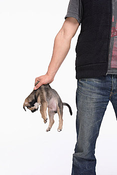 一个年轻的男人手里抓着一只狗