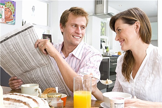 情侣,吃早餐,厨房用桌,男人,拿着,报纸,微笑,女人