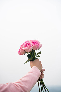 手拿一束玫瑰花