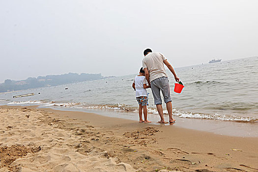 夏日大海边游玩的父子