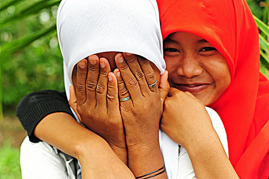 indonesia,sumatra,banda,aceh,two,shy,girl,friends,with,veil,and,hiding,in,front,of,camera