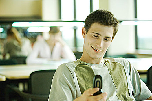 男性,大学生,坐,书房,看,手机,微笑