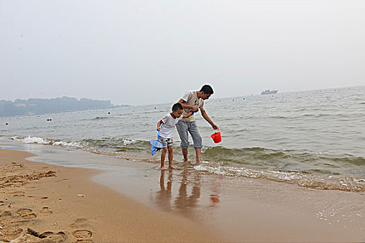 夏日大海边游玩的父子