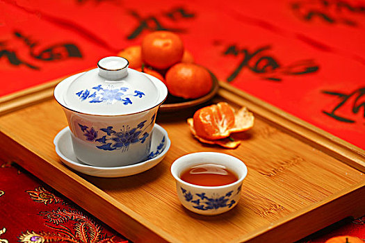 茶具和桔子放在春节红色对联福字背景上