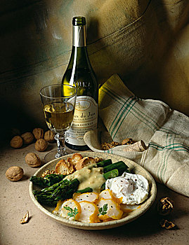 盘子,黑线鳕,荷包蛋,绿芦笋,玻璃杯,瓶子,白葡萄酒