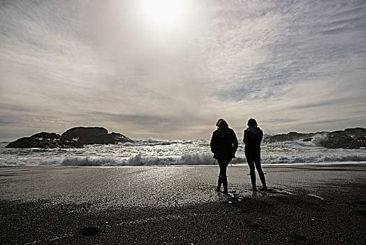 剪影,两个女孩,站立,水边,看,波浪,温哥华岛,不列颠哥伦比亚省,加拿大