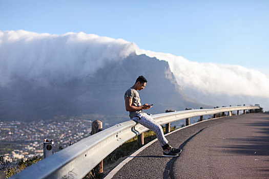 男青年,跑步,坐,乡村道路,屏障,看,智能手机,开普敦,西海角,南非