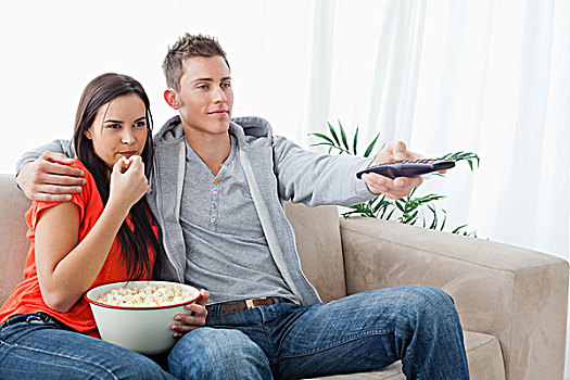 搂抱,坐,夫妇,沙发,一起,看,电视,吃,爆米花
