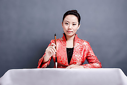 穿中式服装写毛笔字的女性