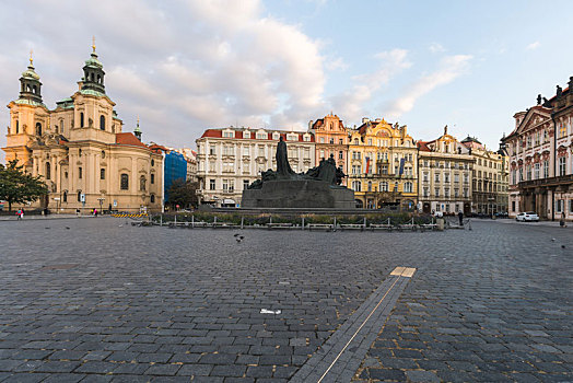 清晨的布拉格广场,广场中央的雕像和远方的圣尼古拉教堂