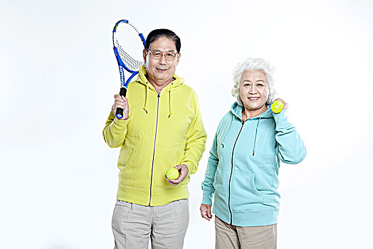 穿运动装拿网球拍的老年夫妇