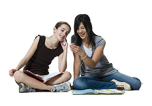 两个女孩,坐,双腿交叉,家庭作业,mp3播放器