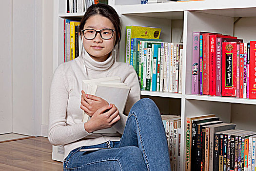 女孩在書櫥前看書