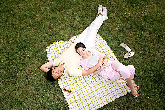 年轻情侣躺在草地上