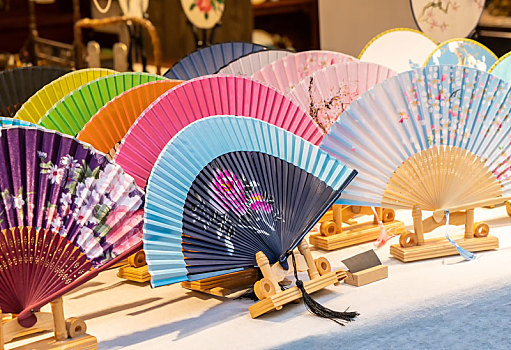 桌上展示的各色中国传统丝绸折扇