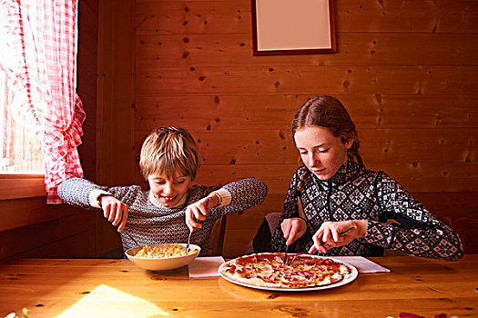 少女,兄弟,吃饭,意大利面,比萨饼,木房子,桌子