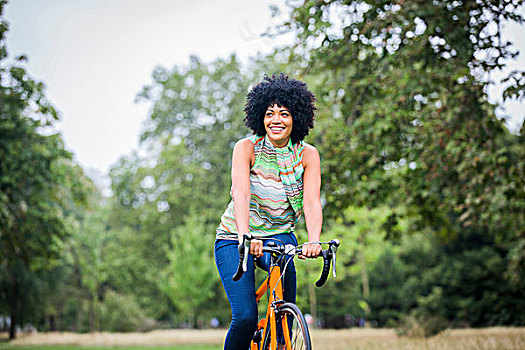 正面,成年,女人,非洲式发型,骑自行车,看别处,微笑