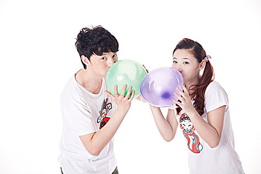 年轻情侣一起吹气球