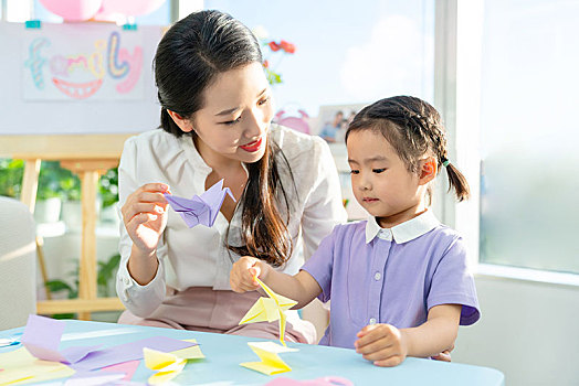 老师和小女孩一起折纸