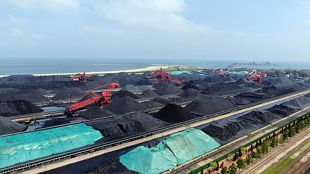 山东省日照市,航拍蓝天白云下的煤炭堆场,运输生产繁忙有序