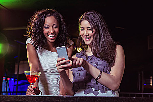 两个女人,看,手机,微笑,吧台,鸡尾酒,酒吧