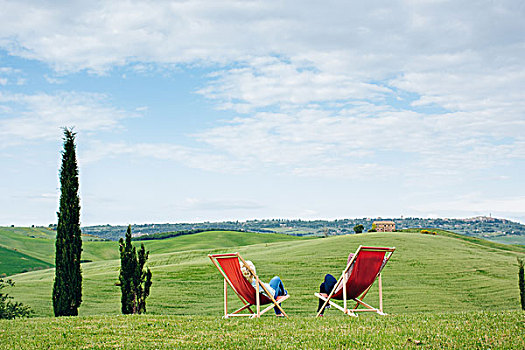 后视图,两个,成熟,女性朋友,坐,红色,折叠躺椅,托斯卡纳,意大利