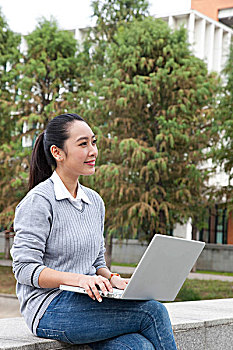 年轻大学生在校园里使用笔记本电脑