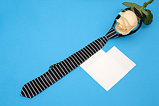 蓝色背景的黄色玫瑰礼卡和领带