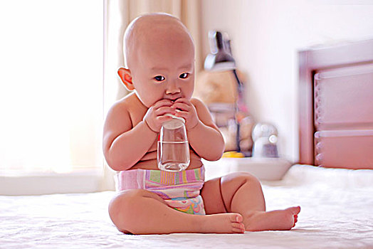 抱着奶瓶在咬的婴儿