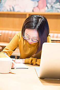 年轻的女性在咖啡馆上网工作